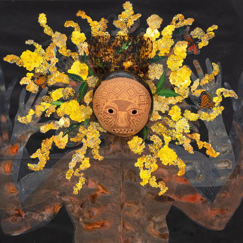 Sculpture of a face mask surrounded by colorful shapes resembling rays of the sun.